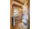 Log cabin bathroom featuring a pedestal sink, rustic wood walls, and unique bovine shower curtain at 2932 Rant Drum Rd, Maiden, NC 28650