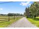 Long gravel driveway with wooden fence leading to a charming country home at 2932 Rant Drum Rd, Maiden, NC 28650