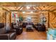 Comfortable log cabin living room with rustic wood walls, leather furnishings, and ample seating at 2932 Rant Drum Rd, Maiden, NC 28650