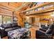 Cozy log cabin living room with vaulted ceilings, wood beams, and comfortable leather furnishings at 2932 Rant Drum Rd, Maiden, NC 28650
