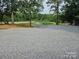 Large gravel parking area with a pond and fountain in the background at 2932 Rant Drum Rd, Maiden, NC 28650