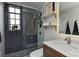 Bathroom with tiled shower and floor, shelves, vanity and mirror, and a window at 301 W 10Th St # 404, Charlotte, NC 28202