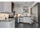 Modern kitchen with stainless steel appliances, black granite countertops, stylish white cabinets, and black slate flooring at 301 W 10Th St # 404, Charlotte, NC 28202
