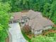 Aerial view of a custom home, featuring lush landscaping, sprawling layout, and an oversized driveway at 3394 Rainbow Dr, Waxhaw, NC 28173