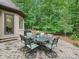 Backyard stone patio featuring a stone table and seating surrounded by a lush forest at 3394 Rainbow Dr, Waxhaw, NC 28173