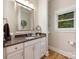 Well-lit bathroom with a granite countertop, white cabinets, shelving and an exterior window at 3394 Rainbow Dr, Waxhaw, NC 28173
