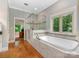 Luxurious bathroom with a soaking tub, frameless shower, and views of the surrounding greenery at 3394 Rainbow Dr, Waxhaw, NC 28173
