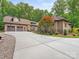 A long, private driveway leads to a custom home with a three car garage and mature landscaping at 3394 Rainbow Dr, Waxhaw, NC 28173