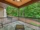Spacious covered porch with tiled floor, railing, providing serene views of the surrounding greenery at 3394 Rainbow Dr, Waxhaw, NC 28173