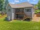 Backyard view featuring a large deck, a door leading to the basement, and a well-maintained lawn at 3633 Longpond Ln, Monroe, NC 28110