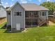 Backyard view featuring a large deck, a door leading to the basement, and a well-maintained lawn at 3633 Longpond Ln, Monroe, NC 28110
