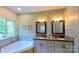 Bathroom featuring double vanities, granite countertops, and a soaking tub at 3633 Longpond Ln, Monroe, NC 28110