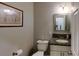 Cozy half-bathroom boasts granite countertop vanity, framed mirror, and charming wall art at 3633 Longpond Ln, Monroe, NC 28110