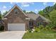 Charming brick home with a two-car garage, well-manicured lawn, and inviting front entrance at 3633 Longpond Ln, Monroe, NC 28110