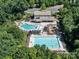 Aerial of a community center with pools, a slide, and a playground surrounded by trees at 4009 Oxford Mill Rd, Waxhaw, NC 28173