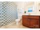 Bright bathroom with a patterned shower curtain and a warm wood vanity at 4009 Oxford Mill Rd, Waxhaw, NC 28173