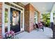Charming covered porch featuring brick accents, a colorful wreath, and cozy seating at 4009 Oxford Mill Rd, Waxhaw, NC 28173