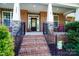 Inviting front porch features brick steps, black railings, and a decorative wreath at 4009 Oxford Mill Rd, Waxhaw, NC 28173