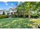 Charming two-story home boasts a lush green lawn, stone accents, and mature trees at 4009 Oxford Mill Rd, Waxhaw, NC 28173