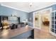 Well-lit home office with built-in shelving, a spacious desk, and French door access at 4009 Oxford Mill Rd, Waxhaw, NC 28173