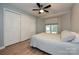 Comfortable bedroom with hardwood floors, a ceiling fan, closet, and a large window for natural light at 433-68 W 8Th St, Charlotte, NC 28202