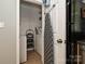 Organized laundry area featuring a stacked washer/dryer and ironing board with storage shelves at 433-68 W 8Th St, Charlotte, NC 28202