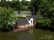 Aerial view of a lakefront house with private deck and mature landscaping at 5104 Top Seed Ct, Charlotte, NC 28226