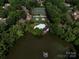 Aerial view of a lakefront community with tennis courts and community pool at 5104 Top Seed Ct, Charlotte, NC 28226