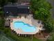 Aerial view of community pool with patio, furniture, pool house, and mature trees at 5104 Top Seed Ct, Charlotte, NC 28226