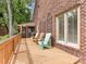 Backyard deck featuring a brick facade, mature trees, a sitting area, and a screened in porch at 5104 Top Seed Ct, Charlotte, NC 28226