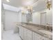 Bright bathroom with skylight, double sinks, granite counters, and a large mirror at 5104 Top Seed Ct, Charlotte, NC 28226