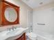 Bathroom featuring a pedestal sink, wooden mirror frame, and shower-tub combo with white tile surround at 5104 Top Seed Ct, Charlotte, NC 28226