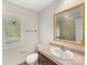 Bathroom with tiled countertop, wood cabinets, framed mirror and natural light at 5104 Top Seed Ct, Charlotte, NC 28226