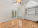 Bright bedroom with built-in shelving and cabinets, hardwood floors, and large windows with plantation shutters at 5104 Top Seed Ct, Charlotte, NC 28226