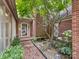 A close-up view of the front entryway, showcasing the brickwork, unique tree, and stone bench at 5104 Top Seed Ct, Charlotte, NC 28226