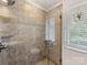 Tiled walk-in shower with built-in shelving, a window, and glass door at 5104 Top Seed Ct, Charlotte, NC 28226