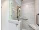 Modern tiled shower with glass door, built-in seat, and grab bar for accessibility at 5104 Top Seed Ct, Charlotte, NC 28226
