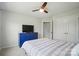 This bedroom features a ceiling fan, dresser with a TV, and a comfortable bed with patterned bedding at 5334 Orchid Bloom Dr, Fort Mill, SC 29707