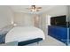 Comfortable bedroom featuring a tray ceiling, ceiling fan, large window, neutral décor, blue chest and carpeting at 5334 Orchid Bloom Dr, Fort Mill, SC 29707