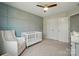 This Bedroom features a grey accent wall, crib, chair, and changing table at 5334 Orchid Bloom Dr, Fort Mill, SC 29707