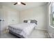 This spacious bedroom features a ceiling fan, natural light, and a comfortable bed with patterned bedding at 5334 Orchid Bloom Dr, Fort Mill, SC 29707