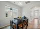 Dining area bathed in natural light, featuring a dark wood table, view to the front yard, with hardwood flooring and neutral colors at 5334 Orchid Bloom Dr, Fort Mill, SC 29707
