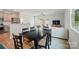 Bright dining area featuring dark wood table, open to kitchen with stainless steel fridge and living room with lots of natural light at 5334 Orchid Bloom Dr, Fort Mill, SC 29707