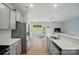 Bright open kitchen with stainless appliances, white countertops, and seamless flow to living area at 5334 Orchid Bloom Dr, Fort Mill, SC 29707