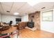 Basement living room with wood floors, a brick wall, and a cozy wood-burning stove at 5516 Northwood Dr, Hickory, NC 28601