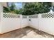 Enclosed back yard featuring concrete and stone with a white lattice-patterned fence and lush greenery at 7012 Somerset Springs Dr # E, Charlotte, NC 28262