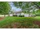 Manicured backyard with lush green grass, bushes, and a white fence at 7012 Somerset Springs Dr # E, Charlotte, NC 28262