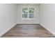 Bright, empty room with a view of trees from double window and hardwood floors at 7108 Hambright Rd, Huntersville, NC 28078