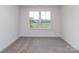 A bedroom with neutral carpet and a large window offering natural light and a view at 7108 Hambright Rd, Huntersville, NC 28078