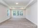 Bright bedroom featuring neutral carpet, natural light, and tray ceiling at 7108 Hambright Rd, Huntersville, NC 28078